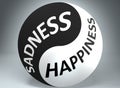 Sadness and happiness in balance - pictured as words Sadness, happiness and yin yang symbol, to show harmony between Sadness and Royalty Free Stock Photo