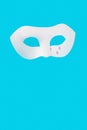 Sadness and loneliness expressed by a theatrical mask with tears on a blue background.