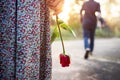 Sadness Love in Ending of Relationship Concept, Broken Heart Woman Standing with a Red Rose on Hand, Blurred Man in Back Side Royalty Free Stock Photo