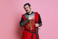 One young man, medieval warrior or knight wearing wearing armor clothing posing isolated over pink background Royalty Free Stock Photo