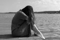 Sadness Woman Sitting by the River on pier. Empty place for text. Bad Day Concept Royalty Free Stock Photo