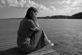 Sadness woman sitting by the river on pier. introvert, fatigue and depression concept with copy space Royalty Free Stock Photo