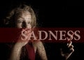 Sadness written on virtual screen. hand of frightened young girl melancholy and sad at the window in the rain. Royalty Free Stock Photo