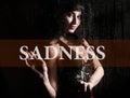 Sadness written on virtual screen. hand of young woman melancholy and sad at the window in the rain. Royalty Free Stock Photo