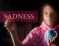 Sadness written on virtual screen. young woman melancholy and sad at the window in the rain, she holding a cup of hot Royalty Free Stock Photo