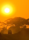 Safari jeep driving through savannah in the sunset Royalty Free Stock Photo