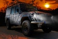 Safari jeep with a zebra pattern drives through a dry hot savana of the nature of Africa Royalty Free Stock Photo