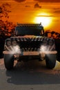 Safari jeep with a zebra pattern drives through a dry hot savana of the nature of Africa Royalty Free Stock Photo