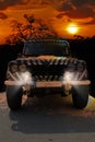 Safari jeep with a zebra pattern drives through a dry hot savana of the nature of Africa Royalty Free Stock Photo