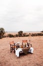 Safari luxury outdoor picnic with African style wooden director chair with wine bucket on table