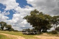 Safari open vehicle parked in deep shade under the tree