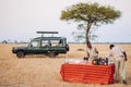 Safari outdoor picnic with beverage bar in Savanna field of Serengeti forest