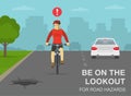 Safe bicycle riding rules and tips. Be on the lookout for road hazards. Front view of a cyclist looking at hole on the road.