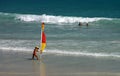 Surf lifesaver placing safety flag at Cable Beach