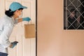 Safe contactless delivery to home during Coronavirus COVID-19 pandemic. Food delivery worker courier wearing face mask and latex Royalty Free Stock Photo