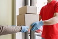 Safe delivery concept. Courier gives boxes to client in mask and gloves.