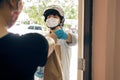 Safe delivery during Coronavirus COVID-19 pandemic. Food delivery courier worker in helmet wearing face mask and latex gloves