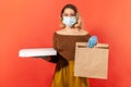 Safe food shopping on quarantine. Woman in protective mask, gloves, glasses holding groceries bag Royalty Free Stock Photo