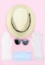 Safe travel from viruses concept,Hat and sunglasses with Medical face mask,white latex medical gloves isolated on pink Royalty Free Stock Photo