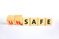 Safe or unsafe symbol. Concept word Safe Unsafe on wooden cubes. Beautiful white table white background. Business safe or unsafe