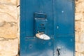 A decorative ornament hangs on an iron mailbox attached to an iron gate on a quiet street in the old part of Safed city in