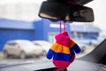 Safety of baby in car. children`s mittens with blue, orange and pink stripes hang on the rear view mirror of a modern Royalty Free Stock Photo