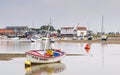 Yacht Club Safety Boat on mud in front of tide mill at Woodbridge on Deben in Suffolk UK Royalty Free Stock Photo