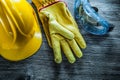 Safety cap leather gloves goggles on vintage wooden board Royalty Free Stock Photo