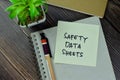 Safety Data Sheets write on sticky notes isolated on Wooden Table Royalty Free Stock Photo