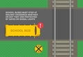 School buses must stop at railway crossings. Top view of a yellow school bus stopped at level crossing.
