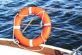 Safety equipment on a boat, life buoy or rescue buoy floating on sea. Royalty Free Stock Photo