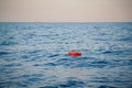 Safety equipment, life buoy or rescue buoy ring with a rope floating in blue sea to rescue people. Yachting, marine background Royalty Free Stock Photo