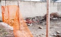 Construction site safety orange net or fence around of remains of hurricane or earthquake disaster damage on ruined old house sele