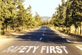 Safety first, message on the road around pine trees. Concept of safe driving and preventing traffic accident Royalty Free Stock Photo