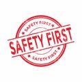 Safety first round grunge red stamp.