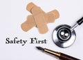 Safety First. Set of adhesive plasters and stethoscope on white background