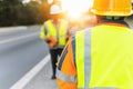 Safety-focused Construction Workers in Vests Collaborating on a Project at Sunrise