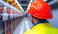 A safety-focused worker in a bright helmet observes an industrial environment, emphasizing commitment to workplace safety