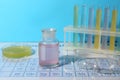 Safety glasses, flask, petri dish and test tubes with different liquids on periodic table of chemical elements Royalty Free Stock Photo