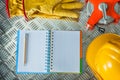 Safety gloves building helmet tape measure notebook pencil on co Royalty Free Stock Photo