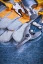 Safety gloves with claw hammer pliers and tin Royalty Free Stock Photo