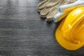 Safety gloves construction plans hard hat on wooden board Royalty Free Stock Photo