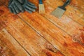 Safety gloves with paint brush and scrape tool placed on old wooden floor Royalty Free Stock Photo