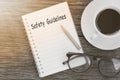 Safety Guidelines text written on a notebook with glasses, pencil and coffee cup on wooden table. Royalty Free Stock Photo