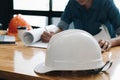 Safety helm with Yong architect man working with blueprints, yon Royalty Free Stock Photo