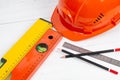 Safety helmet, building construction level, pencil and ruler on a white table. Royalty Free Stock Photo