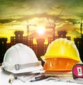 Safety helmet on engineer working table and construction site ba Royalty Free Stock Photo