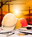 Safety helmet on engineer working table and construction site background Royalty Free Stock Photo