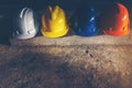 Safety helmet, white, yellow, blue and orange, placed on the cement floor in the construction site Royalty Free Stock Photo