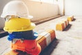 Safety helmet, white, yellow, blue and orange, placed on the cement floor in the construction site Royalty Free Stock Photo